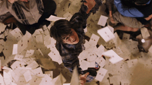 An animated gif from the Harry Potter films, showing envelopes falling from the sky into the arms of a young Harry.