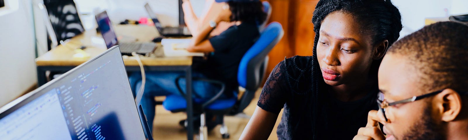 Man and woman looking at computer monitor.