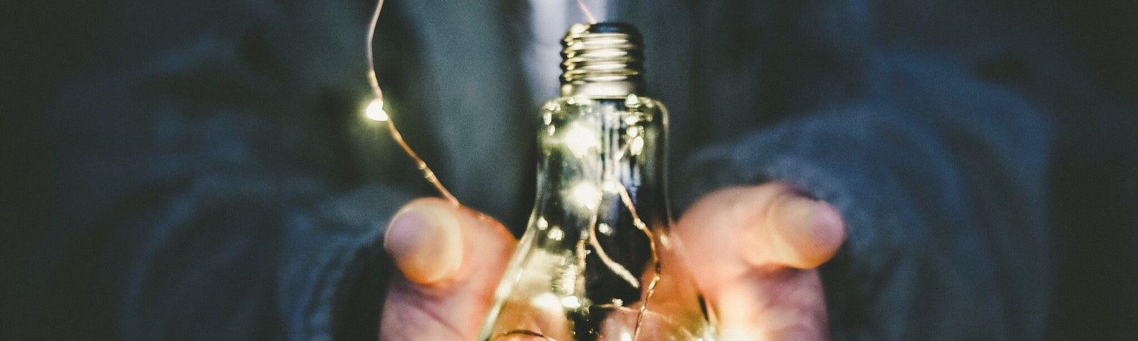 photo of man holding lightbulb in hand; photo on james goydos md 2021 post about mentoring