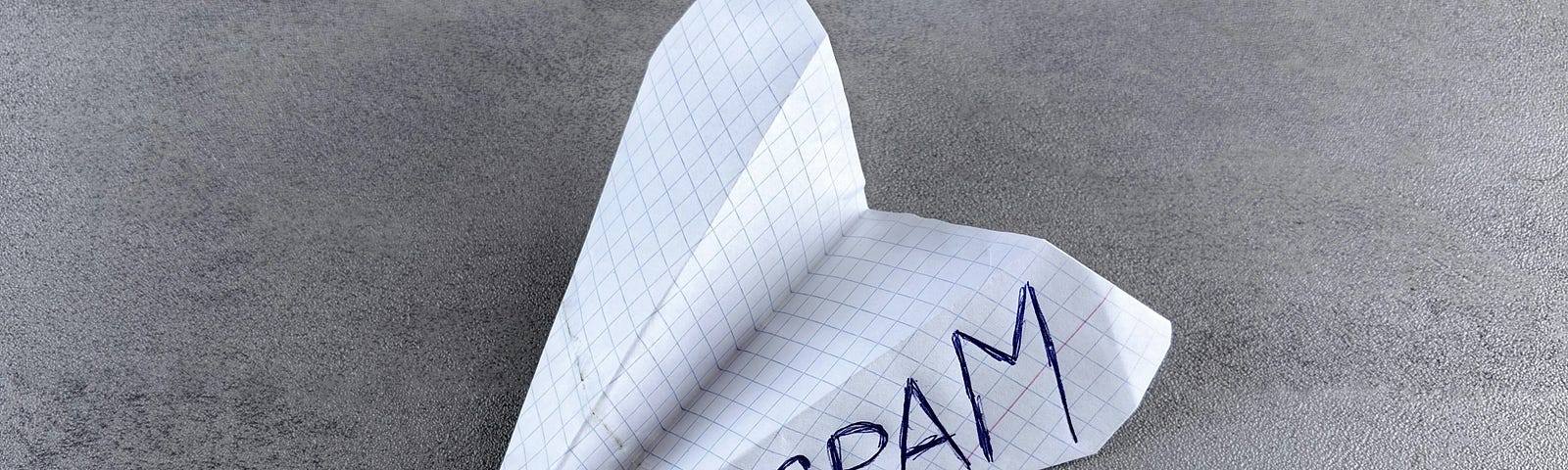 A folded paper airplane with the word spam on it.