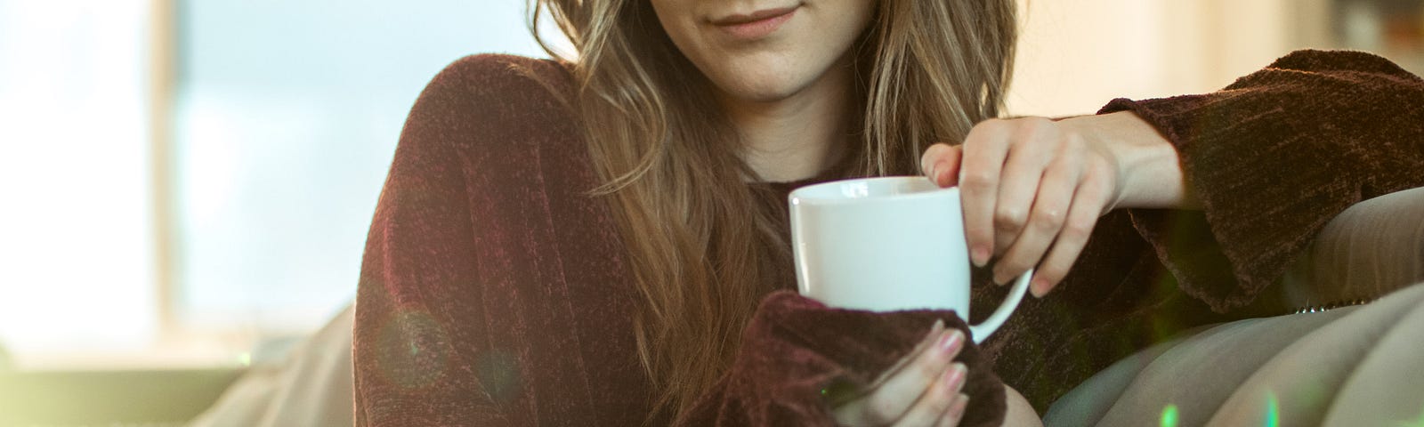 Young woman relaxing on the sofa with a cup of coffee!