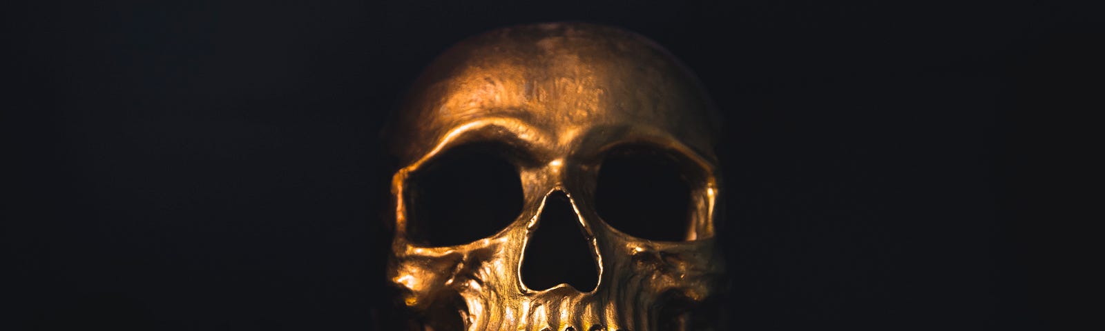 A golden skull shining against a dark background — read to the end of the piece and it will all become clear!