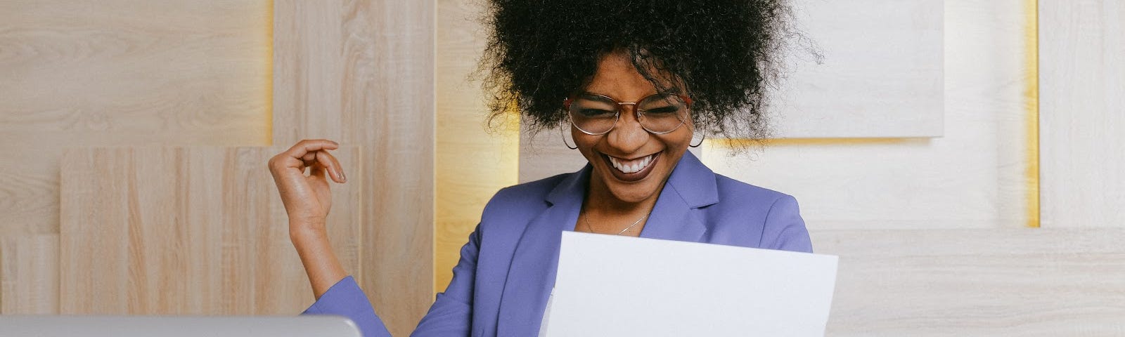 A woman smiling and holding a business document.