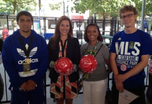 Santos Lopez (L) of the US and Andrew x of Germany (R) present JoAnn Neale of MLS (2nd from L) and Angela Woods (2nd from R) with "Play Unified" balls signed by both squads.
