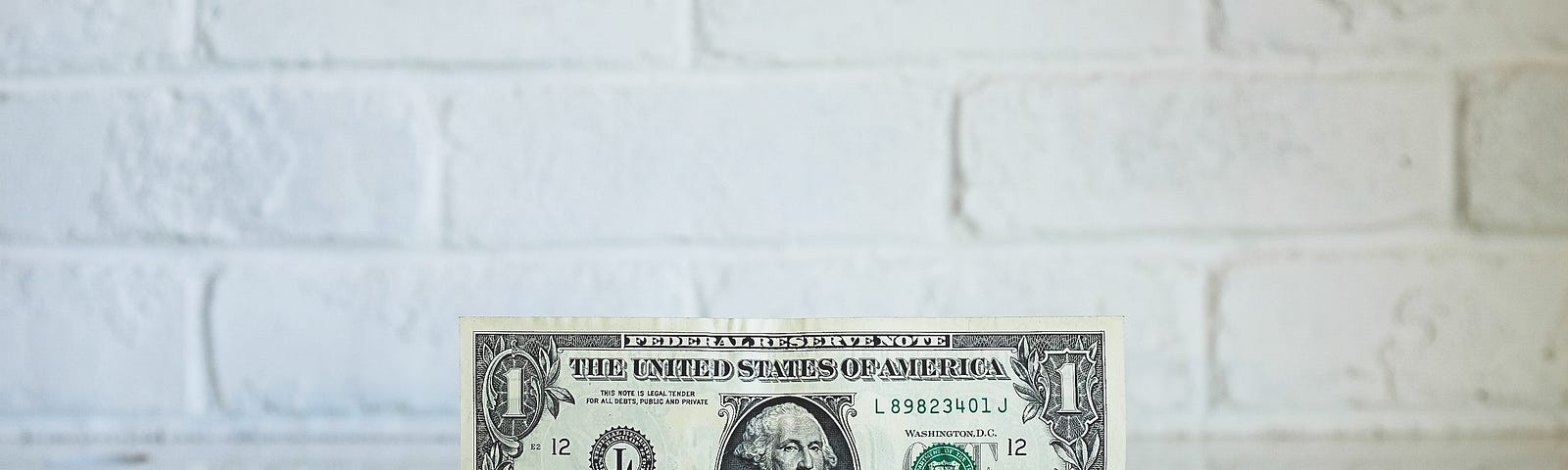 Dollar bill with brick background