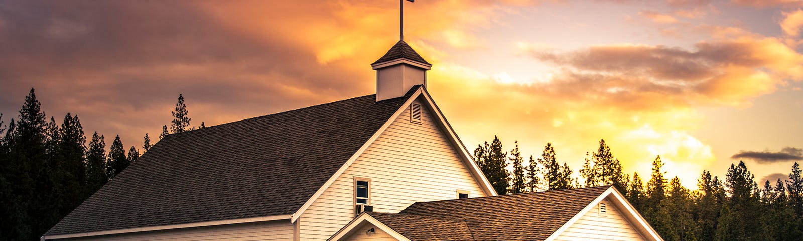 A white church with a sunrise sky