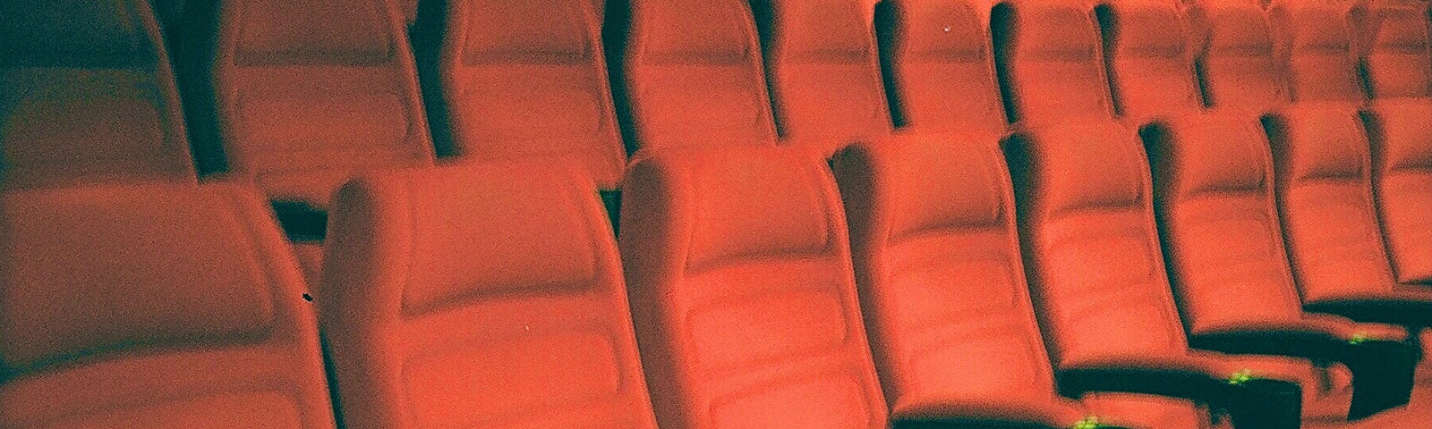 Several rows of red movie theater chairs