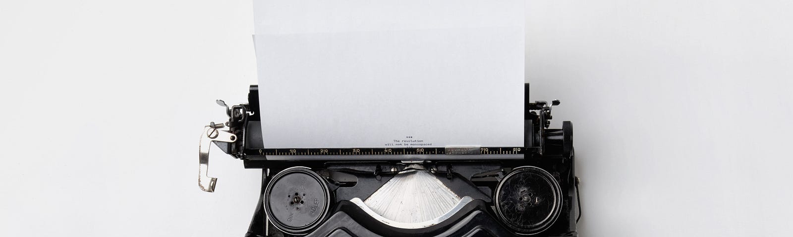 An antigue typewriter with a blank sheet of paper