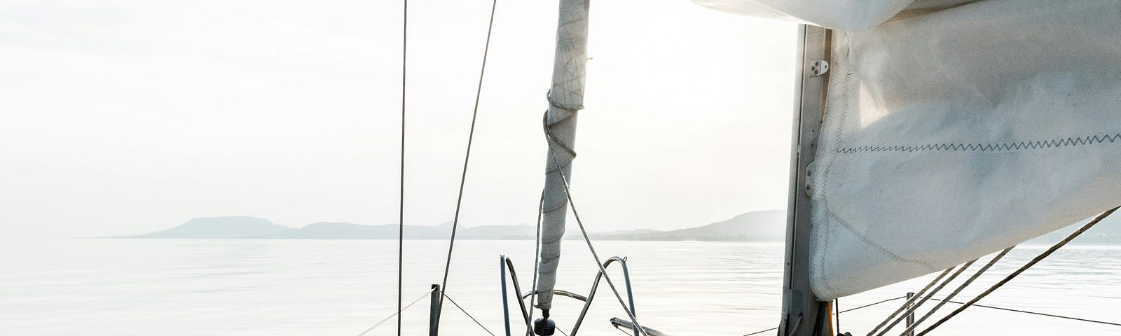The front of a sailboat floating on the water — from the perspective of the sailor.