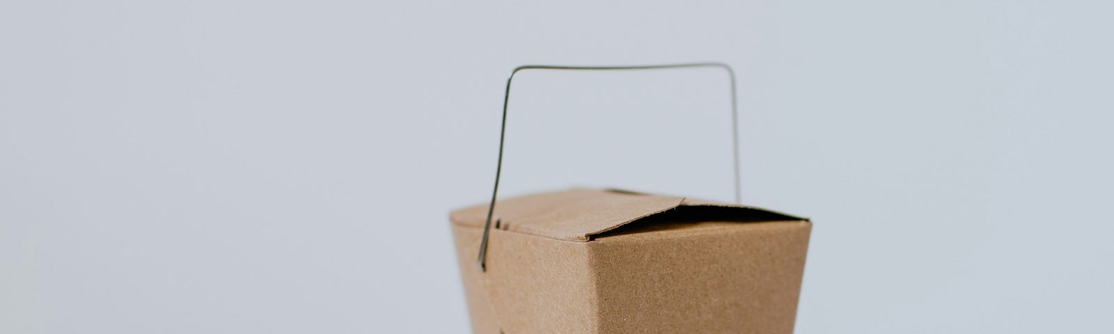 A small paper carryout food box with metal handle