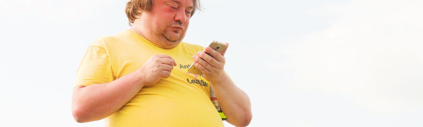 man in yellow t shirt with his belly hanging out