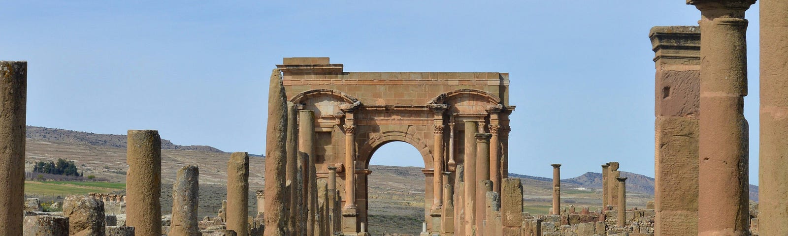 ancient ruins of pillars and a partially torn down structure dating back thousands of years