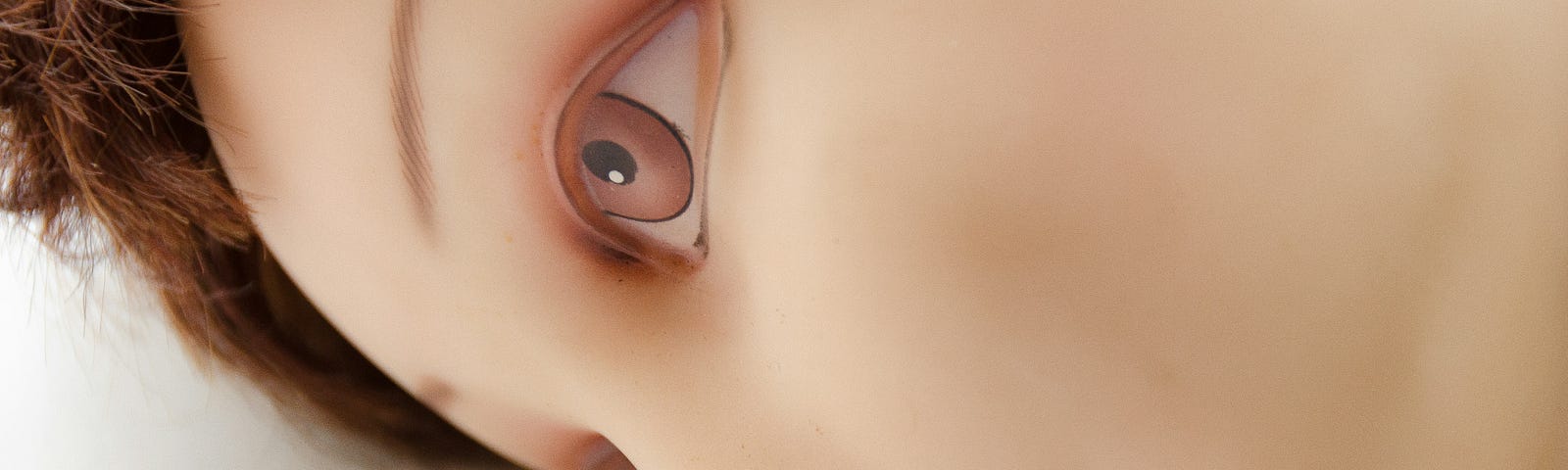 Image of robotic looking head of woman laying down with her eyes wide open but staring unexpressively into the space in front of her.