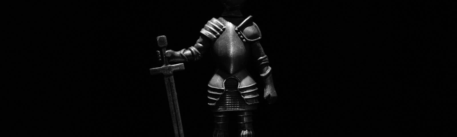 A statuette of a fully armored knight holding a sword point-down