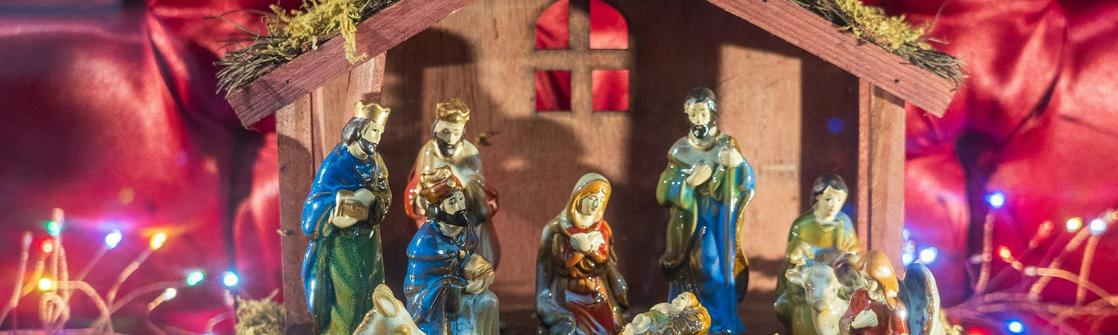 This shows a manger with lights in front of a red background.