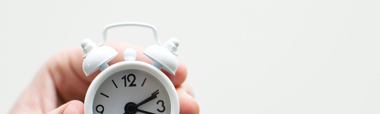 A hand holding a clock.