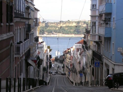 起伏のあるリスボンの街並み、奥に見えるのはテージョ川