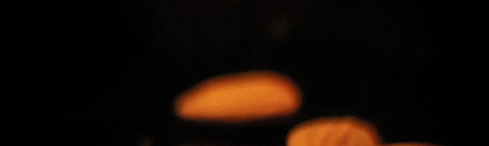 Half a dozen almonds, sharp in the foreground and blurry in the back. Black background.