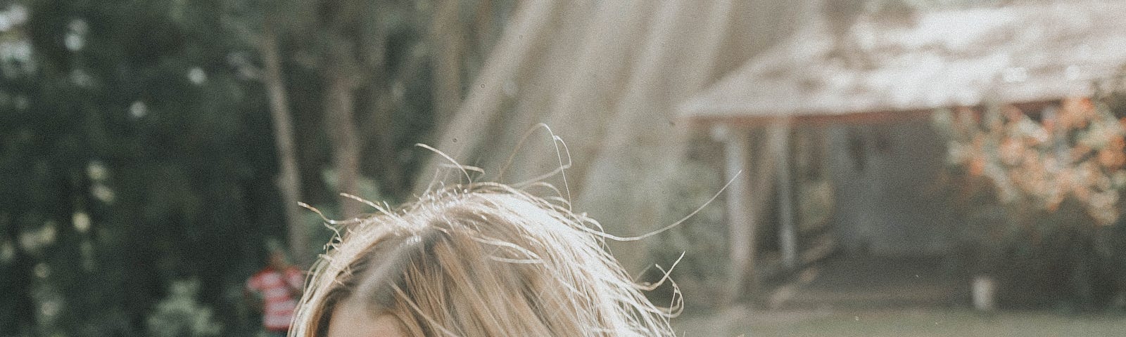 Photo of woman with blonde hair with a sunbeam shinning on her.