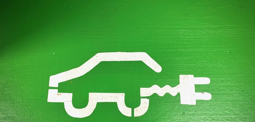 A simple sketch of the outline of a hybrid car, white against green background.