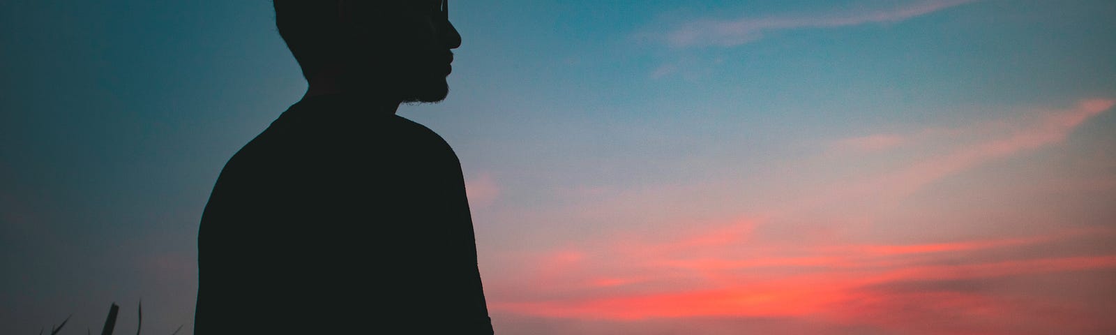 A lonely man under moonlight watching sunset introspecting about what life has become.