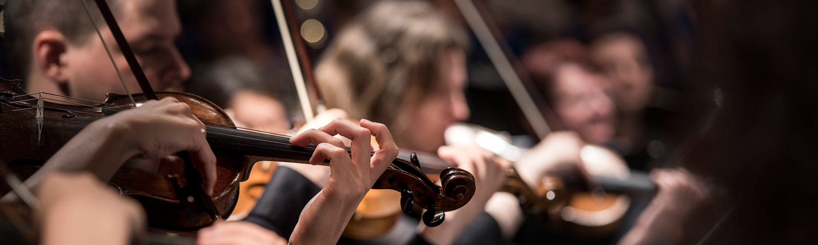 Close-up of the violin section of an orchestra.