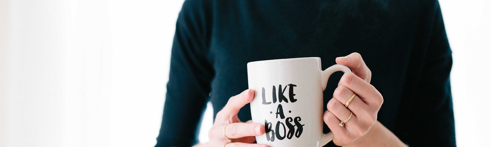 Woman holding a coffee mug that says “Like a Boss”