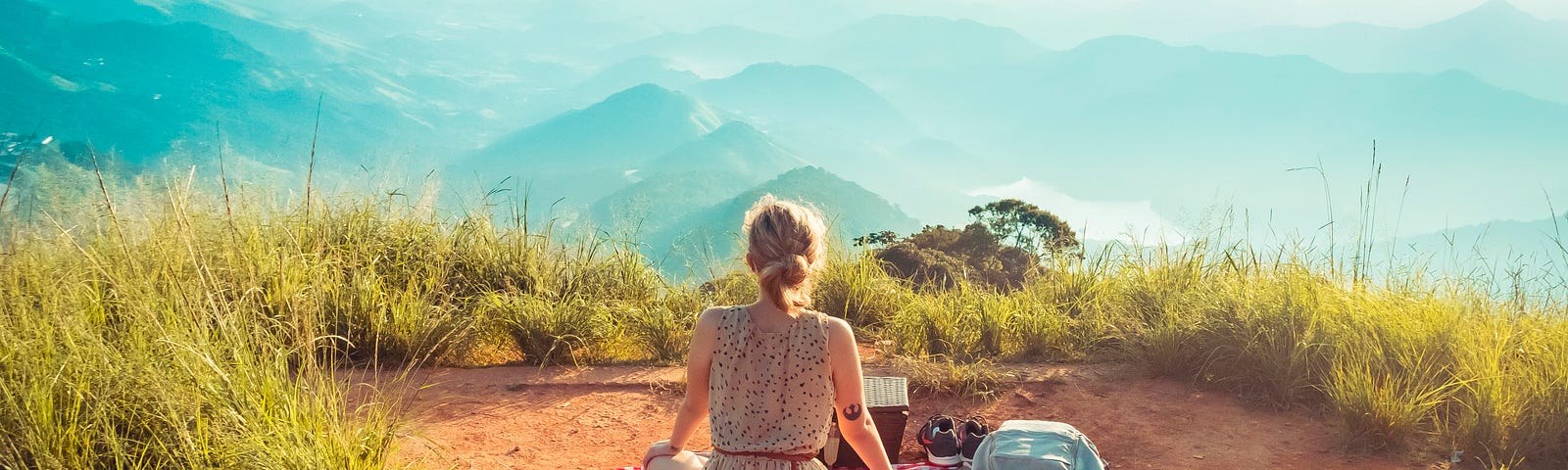 A girl having a picnic on top of the mountain