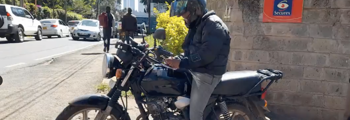 A female motorcycle rider looking at her phone