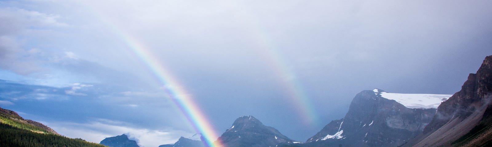 A rainbow shining over a mountain lake.