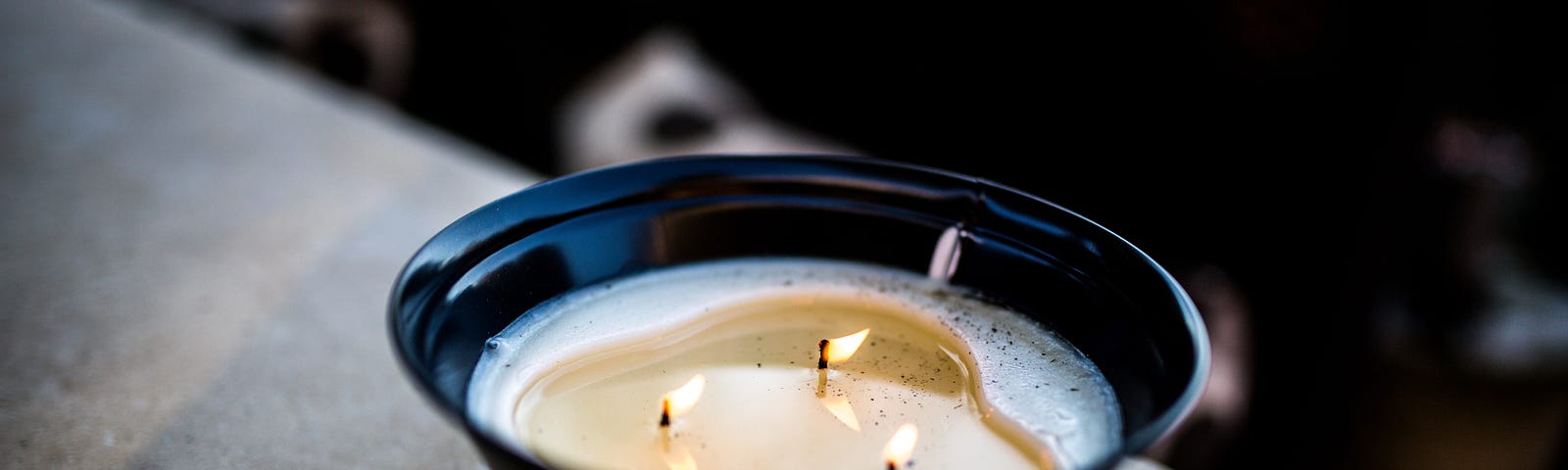 candle with three wicks in a black/blue bowl