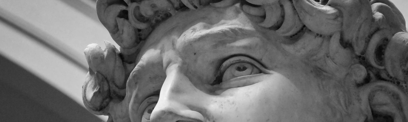 A head shot of a male stone statue.