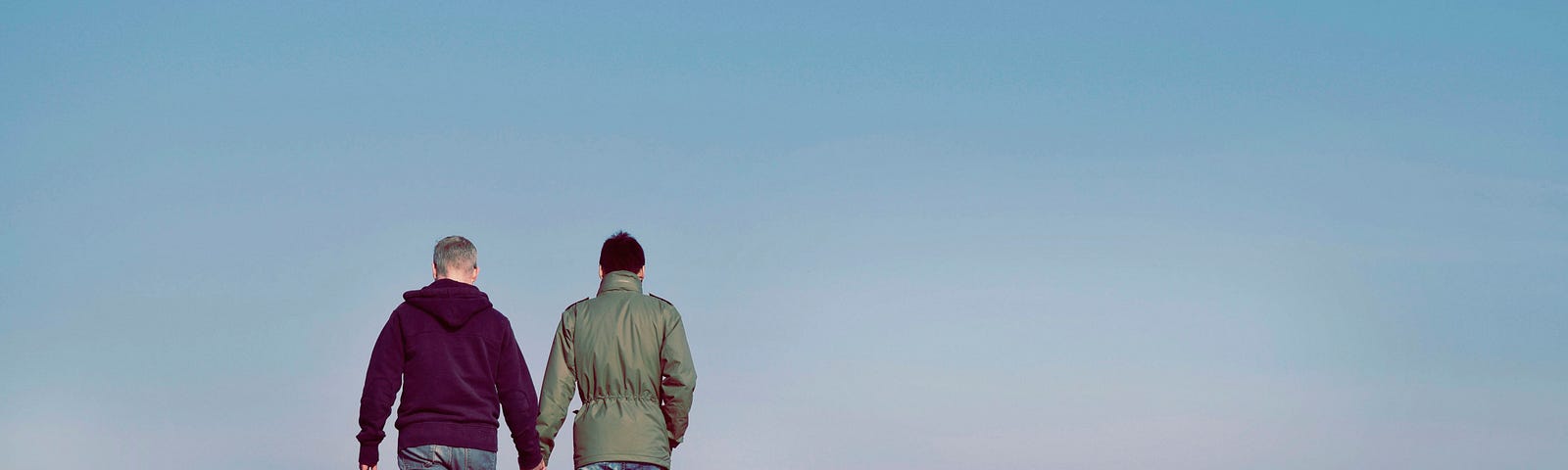 A gay couple walking in the sunshine at the edge of the cosmic ocean.