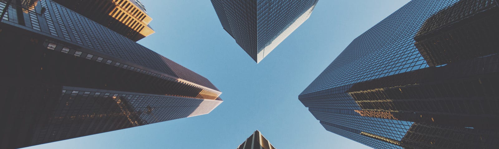 Photo looking up at 4 skyscrapers