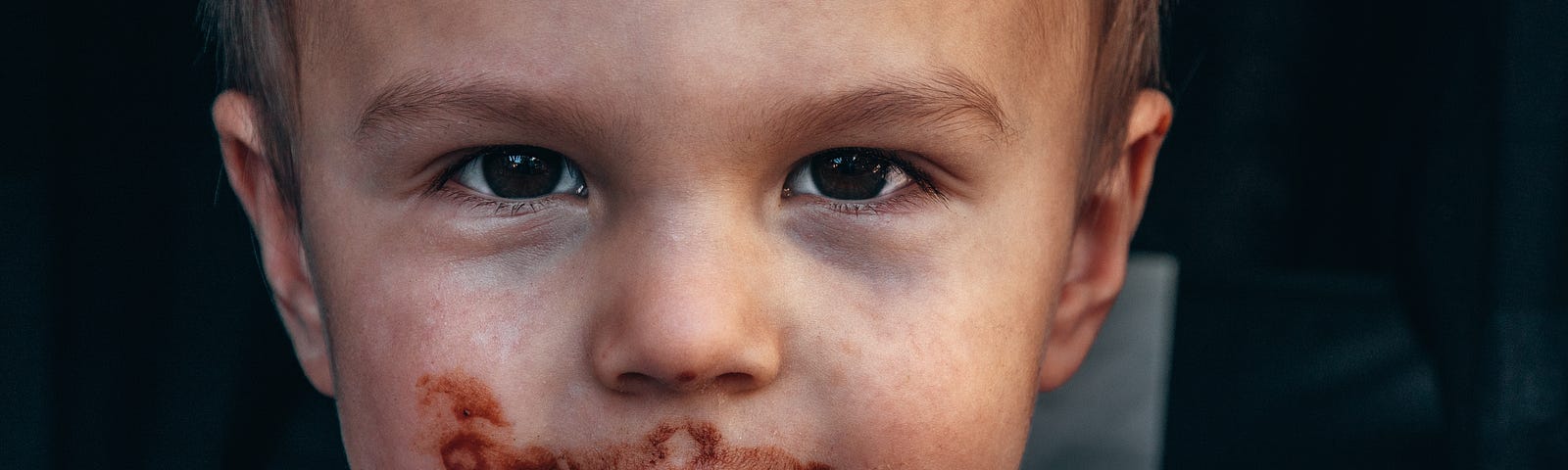 Young boy having chocolate on his mouth