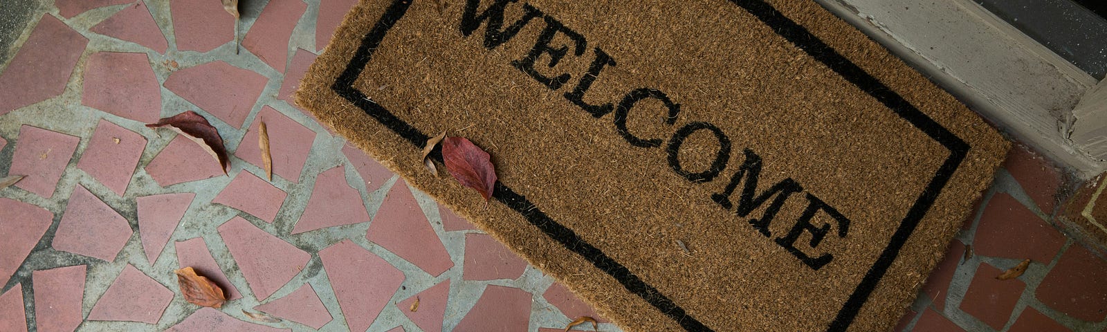 a person approaching a door looking down at a welcome mat