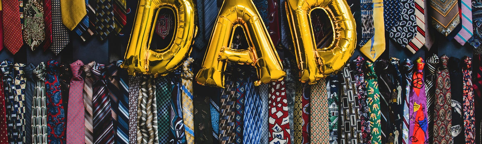 Balloons with the word Dad. Backdrop of rows of neck ties.