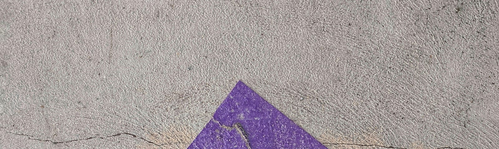 an light red arrow pointing up, against a stone wall