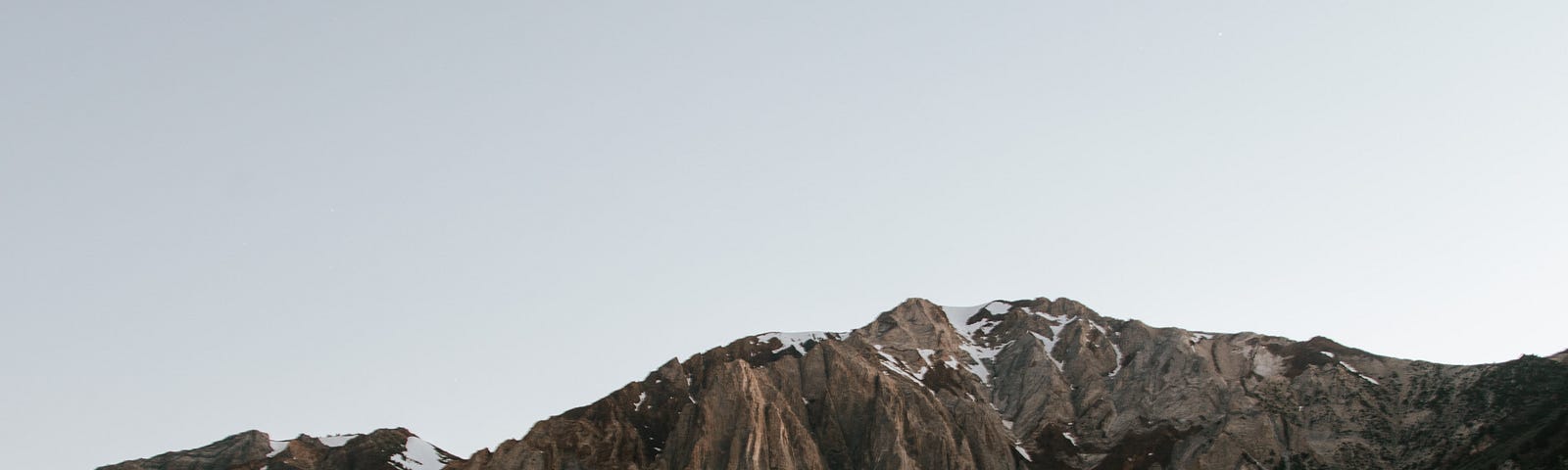 A man with a lantern in front of a lake.