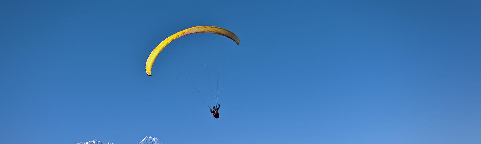 Photo of someone parasailing over mountains