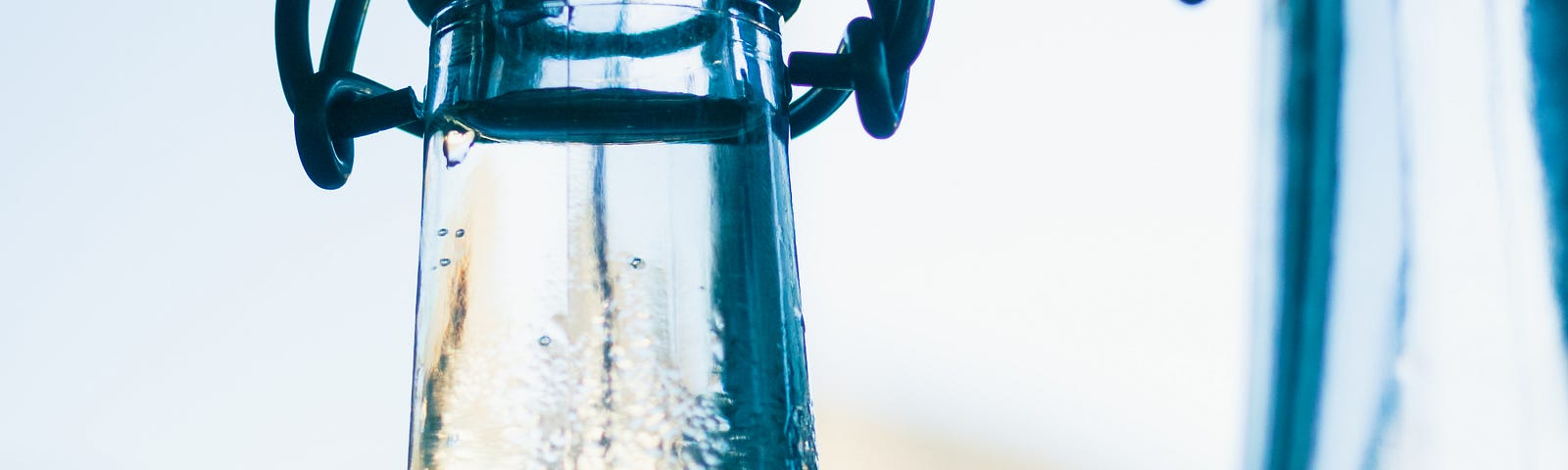 condensation dripping down the necks of clear bottles with swing top lids