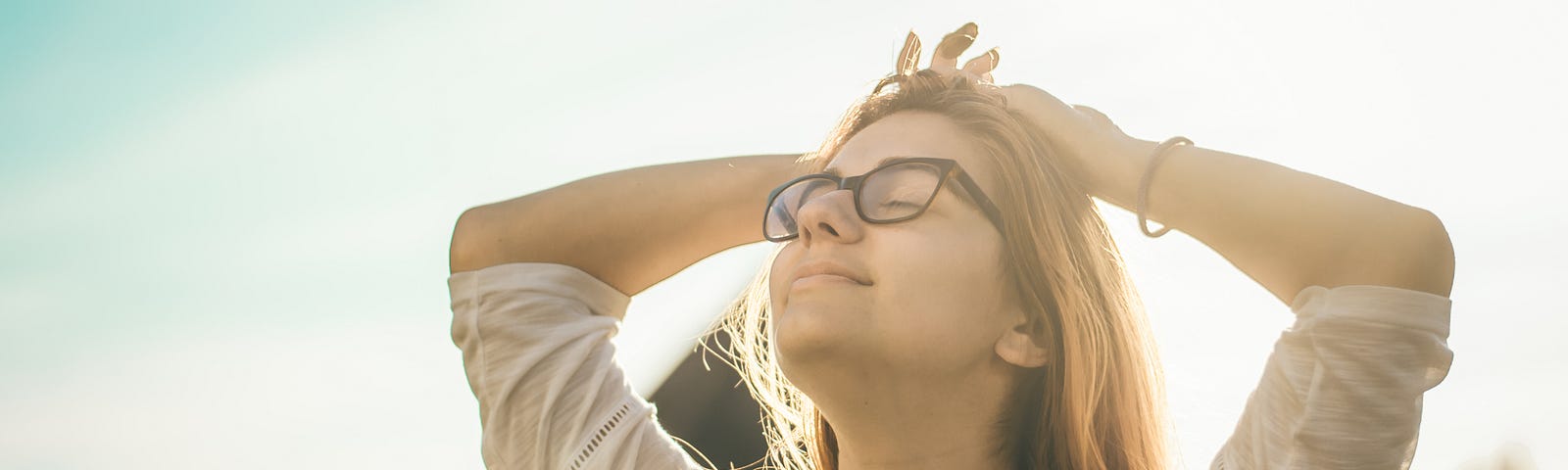 Image of a smiling woman looking up on a sunny day.