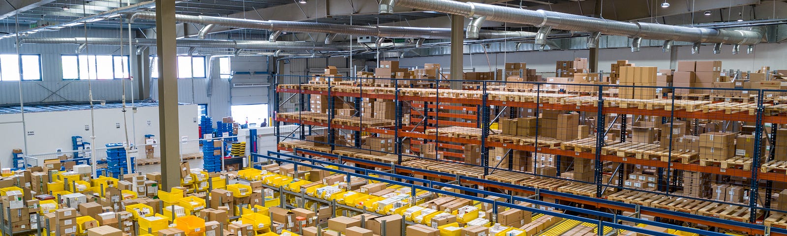 Image of large Amazon warehouse, showing hundreds of rows and thousands of boxes.