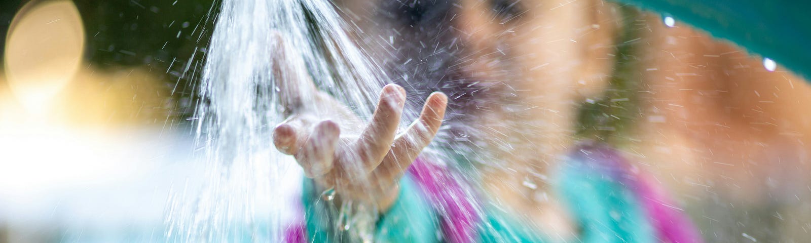 a little girl touching splashing water