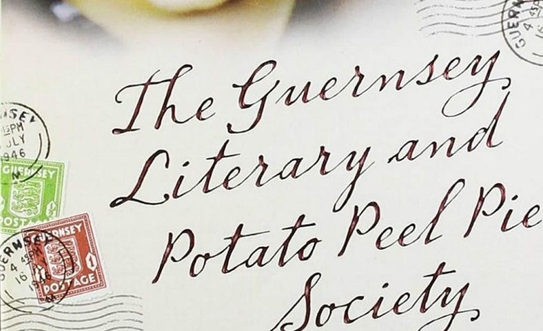 a section of the cover of the much loved book, The Guernsey Literary and Potato Pee Society, showing a few cancelled stamps, a postmark and the title of hte book in an attractive cursive font. Looking like a postcard.