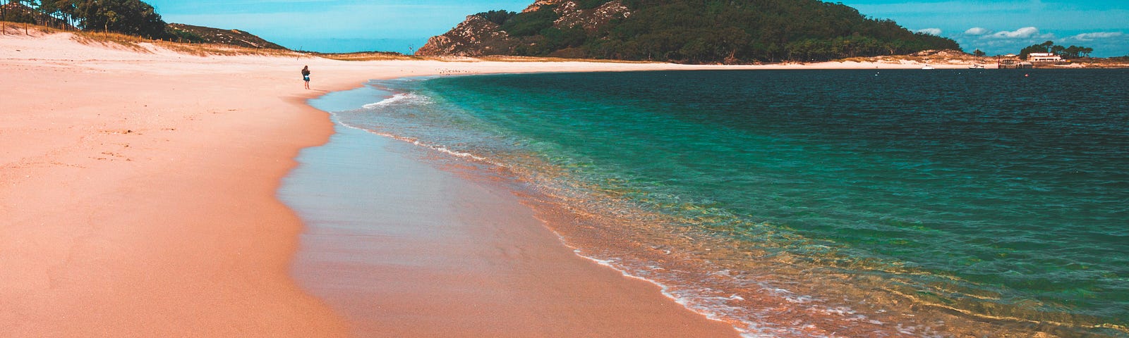 A pinkish beach and the sea