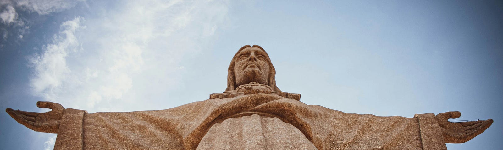 Granite statue of a god with his arms outstretched