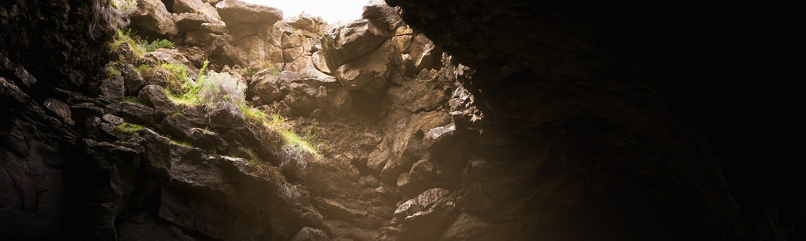 A person, dressed in a gray sweat suit, lost in a cave, surrounded by many racks.