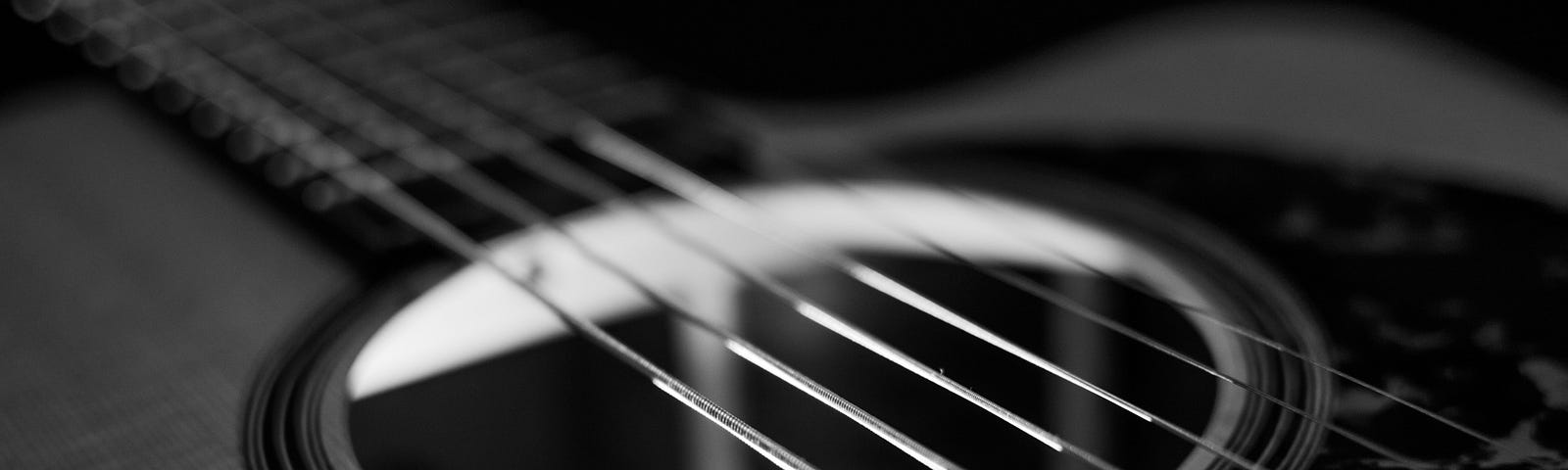 black and white photo of the top of an acoustic guitar