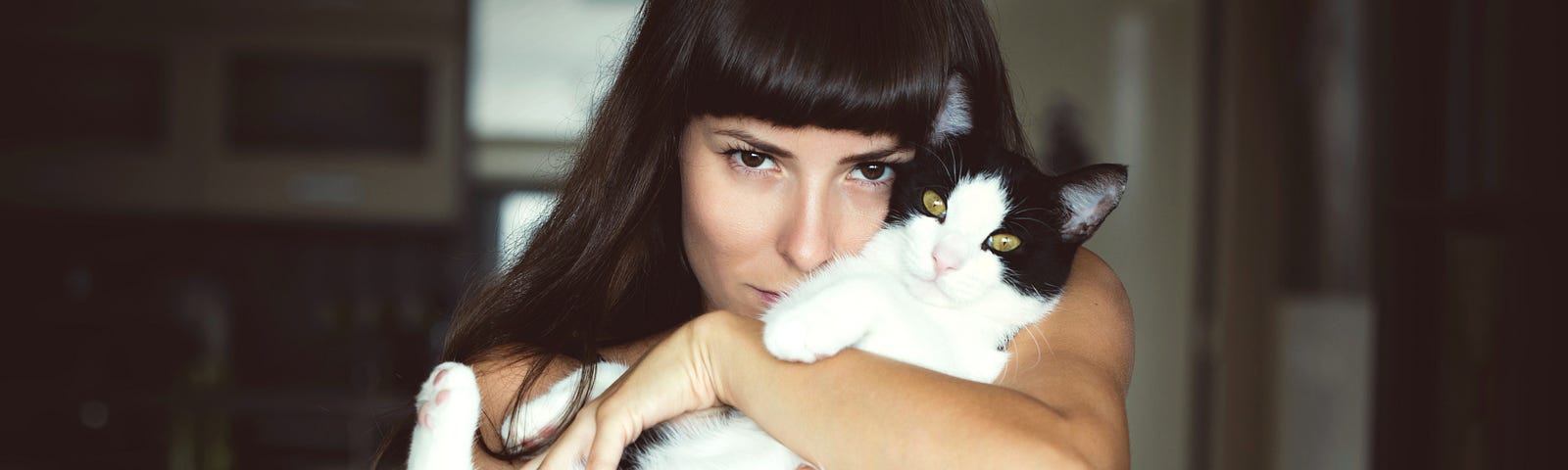woman in bedroom holding a cat
